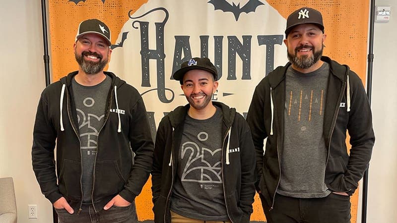Three employees dressed up in matching halloween costumes