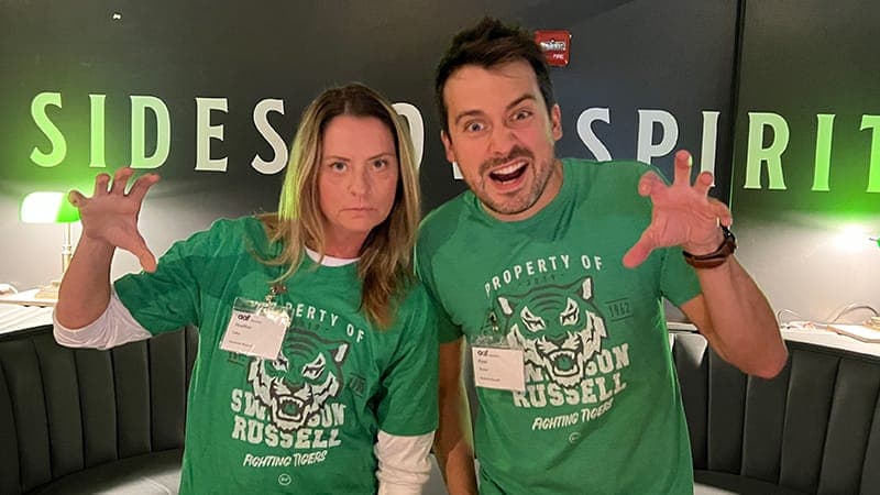 Two employees wearing their Swanson Russell tiger shirts