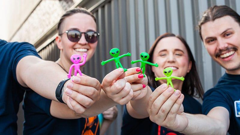 Employees holding up aliens from bowlapalooza