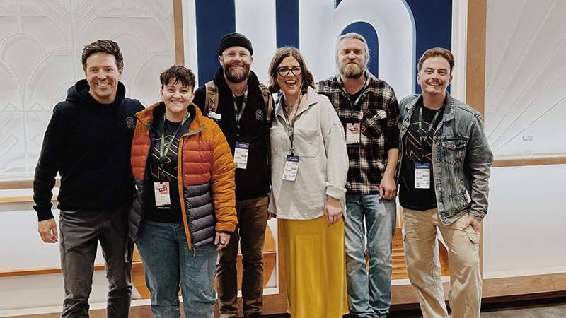 Six employees posing together at an industry conference