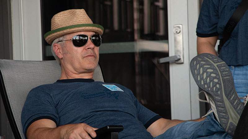 An employee relaxing on a patio chair while wearing sunglasses