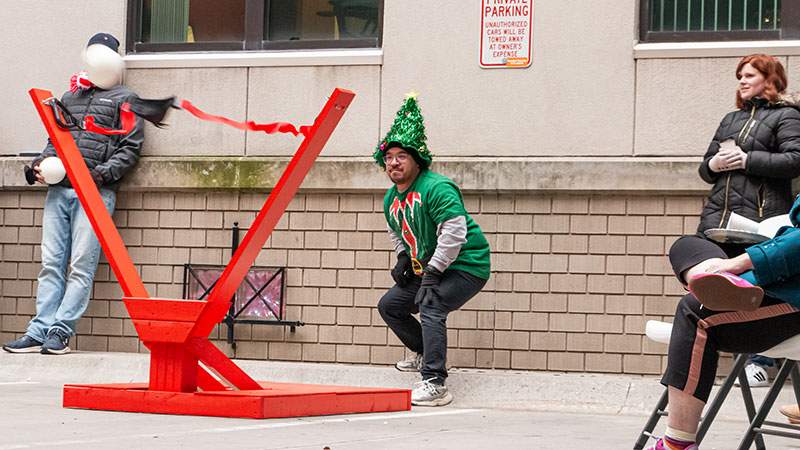 An employee launching a giant slingshot during a winter team event