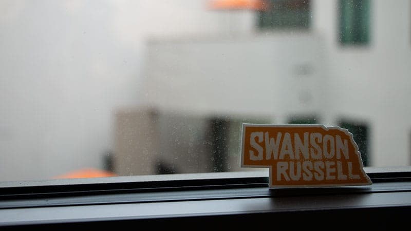 A Swanson Russell sticker sitting in front of a window