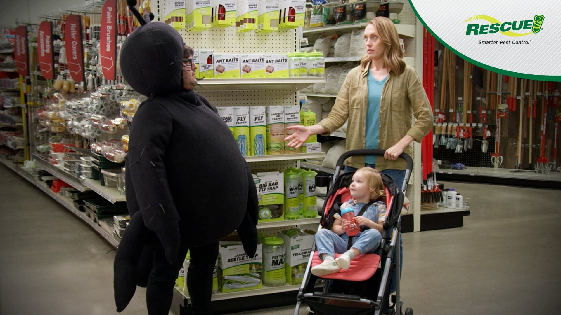 women with child in store talking to man in a spider costume
