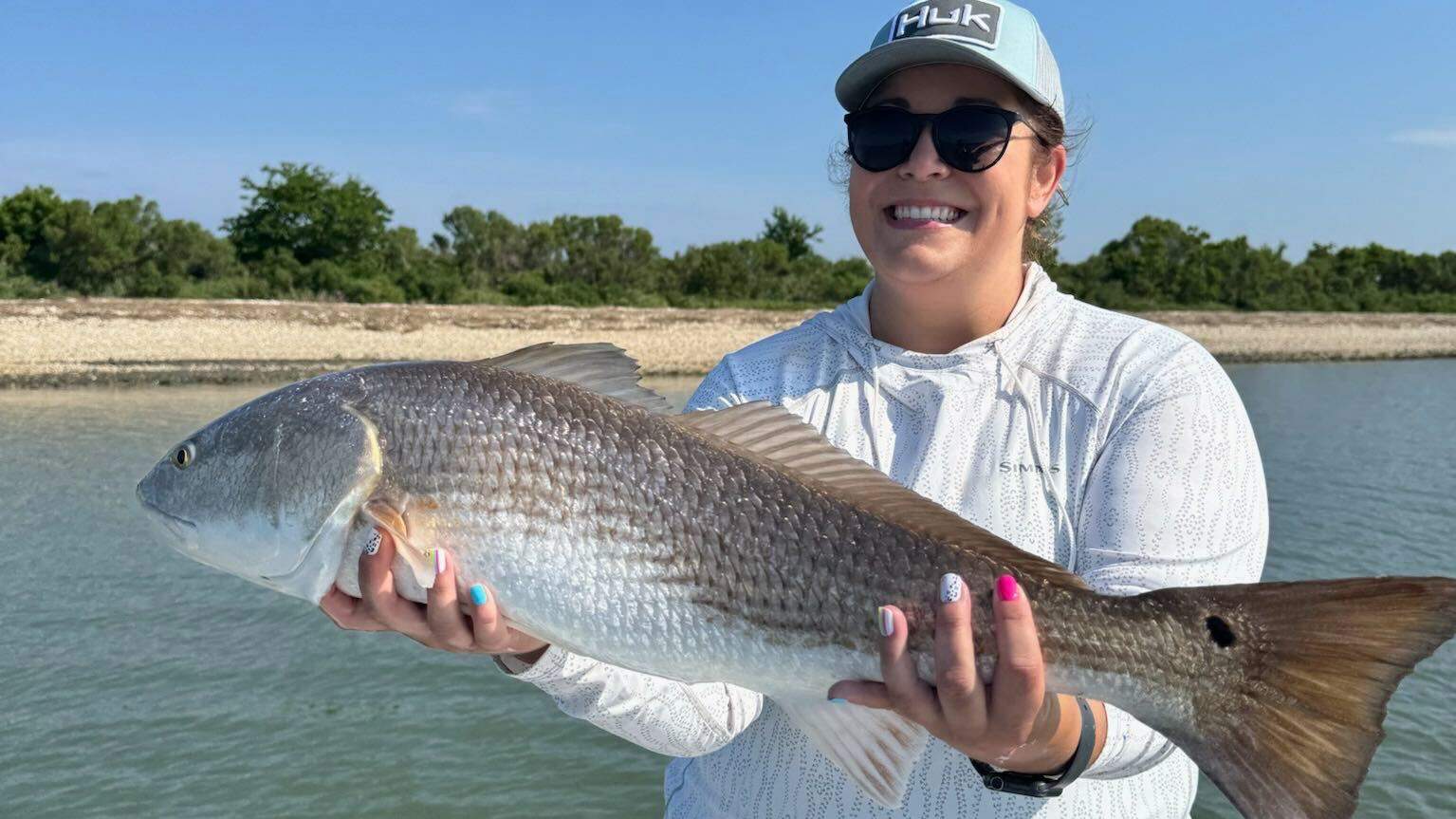 Woman on a boat with a freshly caught fish.