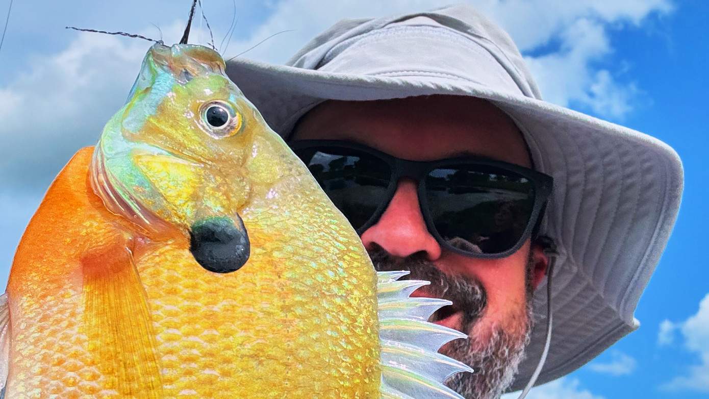 Man holding a freshly caught fish.