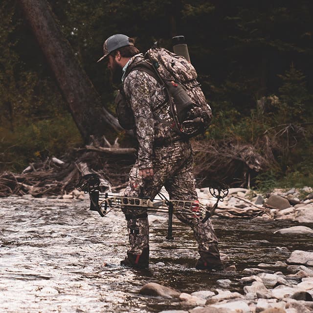 Man in Camo Hunting Gear Crossing a River